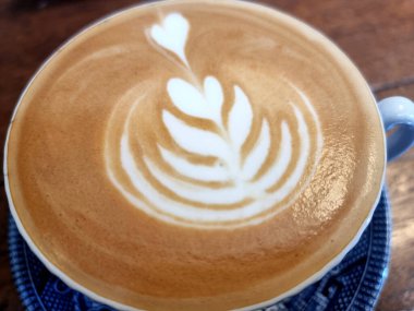 Yanda kahve dükkanı, yakın plan sıcak latte sanat kahvesi arka planı..