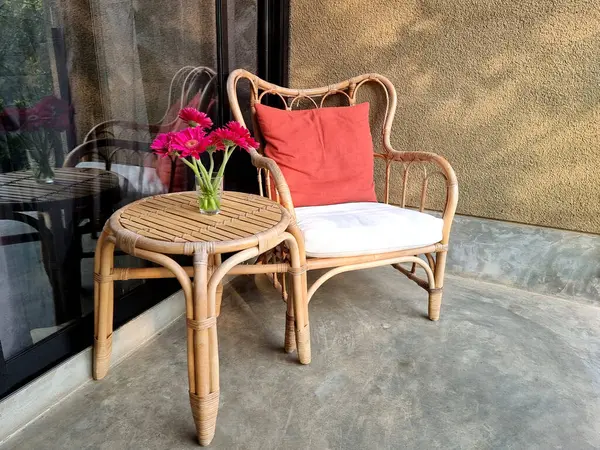 Dinlendirici köşe için mor gerbera çiçekli Rattan sandalye ve masa..