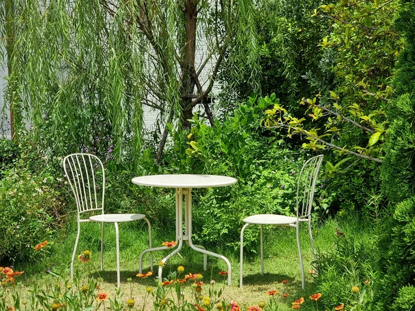 The white table with a chair in the garden