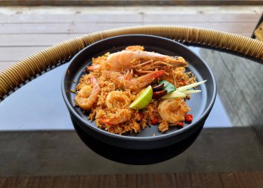 Tom Yum Fried Rice ve karidesler cam masaya dizildi.