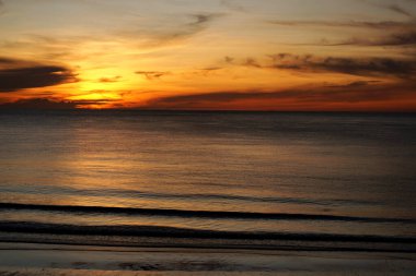 Sabah vakti kumsalda güneş doğmadan önce deniz olan güzel bulutlar.