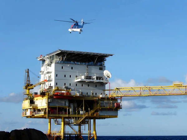 The Helicopter from onshore landing on offshore buildings for passenger transfer to work at offshore oil and gas platforms (take a photo from a boat of offshore marine service)