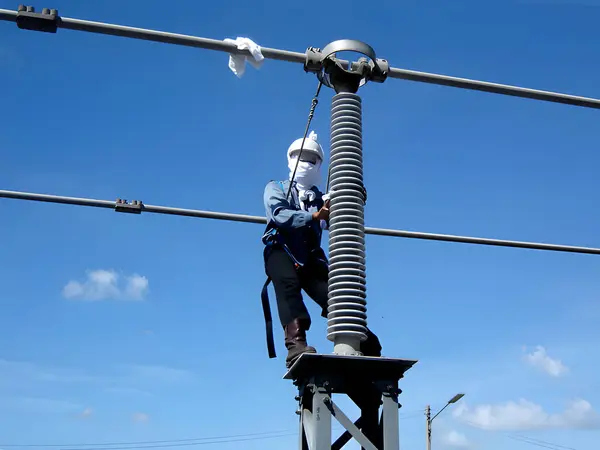 Elektrik Önleyici Bakım, 115kV izolatör servis ekibi tarafından mavi gökyüzü arka planında temizleniyor..