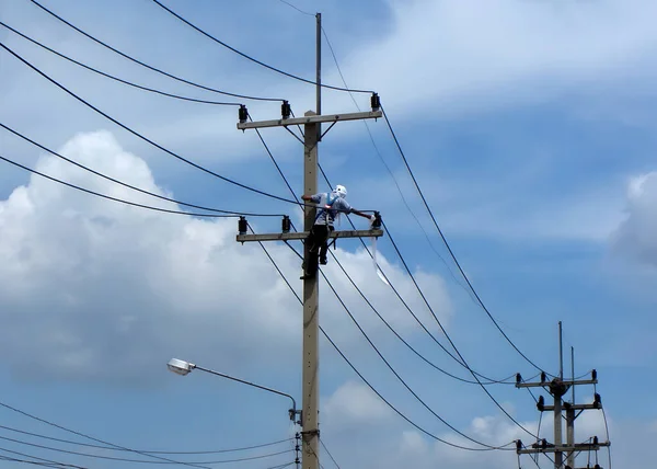 Elektrikçiler, porselen 22kV çalıları temizlemek için elektrik direği üzerinde çalışıyorlar.