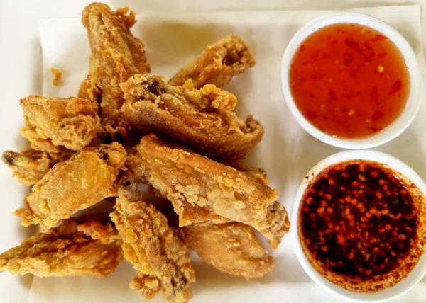 The fried chicken wings with sweet sauce on a table.