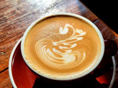 Yanda kahve, masada Swan latte sanat kahvesi..