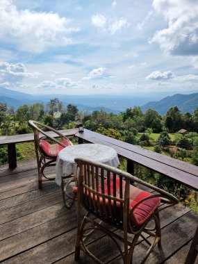 The perspective of rattan chair and table set for a relaxing corner on the mountain range clipart