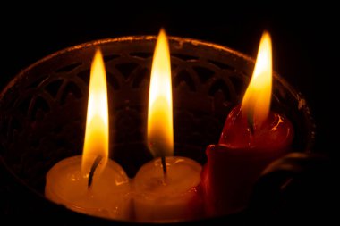 Metal bir mum tutacağında desenleri olan mumlar. Karanlıkta aydınlık. Oda ışıkları. Elektrik kesintisi. Dini tema. Enerjinin konusu. Kurtarıyorum. Hayatta kalmak. Ukrayna 'daki hayatın gerçekleri