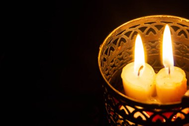 Metal bir mum tutacağında desenleri olan mumlar. Karanlıkta aydınlık. Oda ışıkları. Elektrik kesintisi. Dini tema. Enerjinin konusu. Kurtarıyorum. Hayatta kalmak. Ukrayna 'daki hayatın gerçekleri