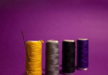 Spikerlere iplik dikiyorum. Farklı renkler. Çelik dikiş iğnesi. Santimetre cinsinden cetvel. Kumaş, giysi ve nakış için dikiş malzemeleri. Ev işleri işte. İğne işi