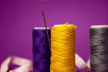 Spikerlere iplik dikiyorum. Farklı renkler. Çelik dikiş iğnesi. Santimetre cinsinden cetvel. Kumaş, giysi ve nakış için dikiş malzemeleri. Ev işleri işte. İğne işi