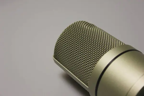 Vokaller, podcastler, akımlar ve diğer ses içerikleri için stüdyo yoğunlaştırıcı mikrofon. Profesyonel ses kaydı. Şarkılar, şarkı sözleri, ses. Metal gövde. Beyaz arka plan. Yakın plan.
