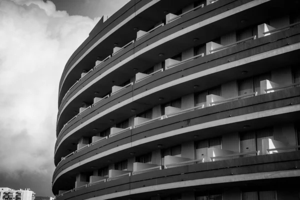 Black an white rounded building hotel or apartments in a spanish seaside volcanic island town