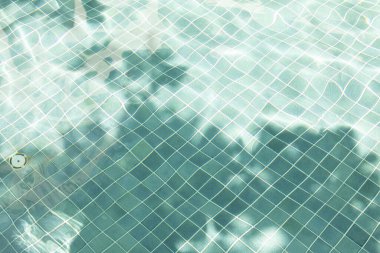 Su yüzeyinde dalgalar olan su yüzeyi dalga etkisi ile havuzun dibindeki mavi karoları görebilirsiniz..