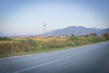 Makedonya 'nın Kocani kentinin kırsal kesiminde, gün batımında dağ destekli pirinç tarlası