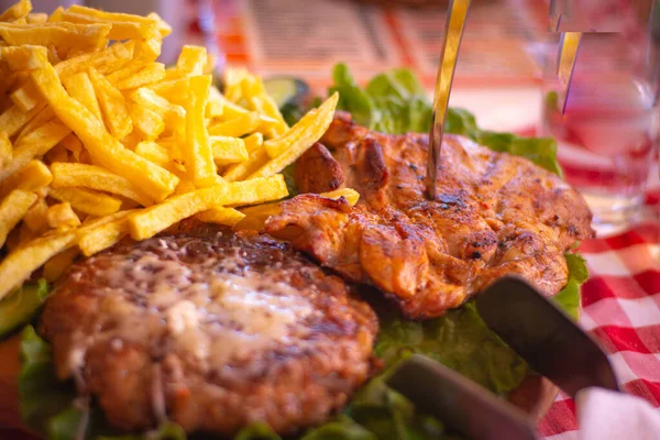 Grilled chicken with french fries on a wooden plate, close up, Macedonia