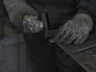 Öğütücüyle metal kesen bir işçi. Sanayi atölyesinde demir öğütürken kıvılcımlar çıkıyor. Makedonya 'nın Kocani kenti yakınlarında