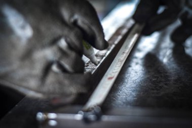 Endüstriyel atölyede metal bar ölçümleri yapan bir işçi. Kocani Makedonya yakınları