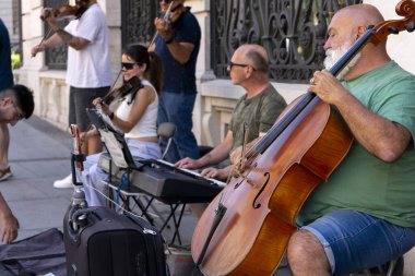Madrid, İspanya, 19 Temmuz 2024: Madrid 'in merkezindeki sokakta keman çalan insanlar