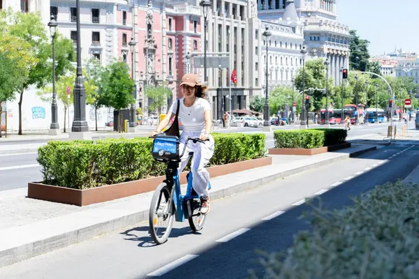 Madrid, İspanya, 19 Temmuz 2024: Madrid 'de kiralık elektrikli bisiklete binen kadın