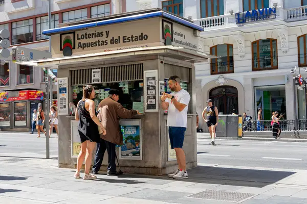 Merkez Madrid, İspanya - 19 Temmuz 2024: İnsanlar Madrid 'deki Gran Via caddesinde bahisler için piyango tezgahından alışveriş yapıyorlar.