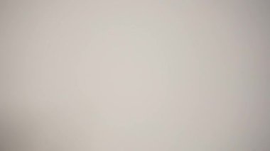 Metin için kopyalama alanı olan beyaz bir arkaplan üzerine mavi yapışkan bir not yerleştiren bir kişi.