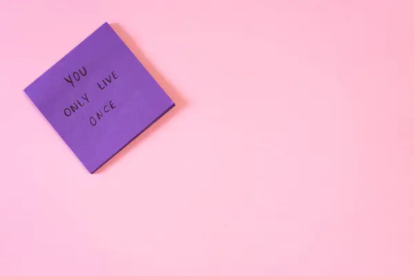 Mor yapışkan nottaki motivasyon mesajı sadece yaşadığını söylüyor. 