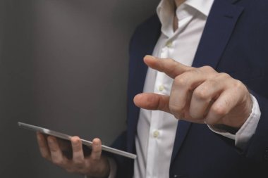 Dijital tablet kullanan bir iş adamı. Tablet bilgisayarı tutan erkeklerin yakın çekim görüntüleri.