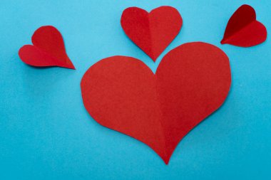 Mavi arka planda kırmızı kağıt kalpler. Sevgililer Günü konsepti. Boşluğu kopyala.