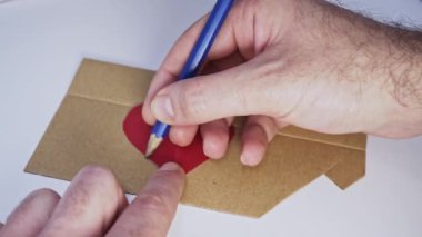 Bir insanın eli kalp çiziyor.