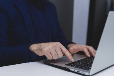 Ofiste dizüstü bilgisayarda çalışan bir iş adamı. Dizüstü bilgisayarda yazan erkek ellerini kapat..