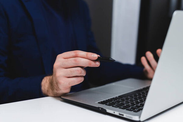 обрезанный взгляд бизнесмена, работающего с ноутбуком в офисе, сосредоточиться на руку