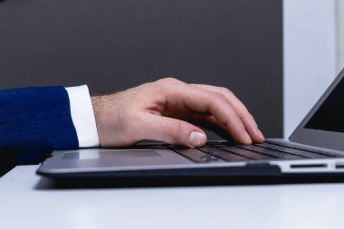 Ofis masasında dizüstü bilgisayarda çalışan bir iş adamı. Yakın plan..