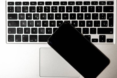 Beyaz arka planda dizüstü bilgisayar ve akıllı telefon. Yukarıdan görüntüle.