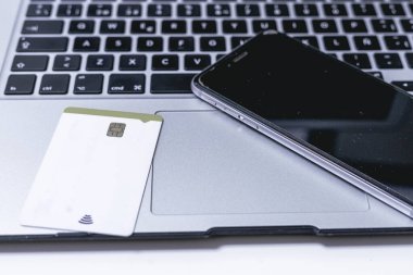 Dizüstü bilgisayarda kredi kartı ve akıllı telefon. Çevrimiçi alışveriş kavramı.