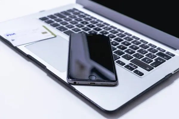 Beyaz arka planda dizüstü bilgisayar ve akıllı telefon. Yakın plan..