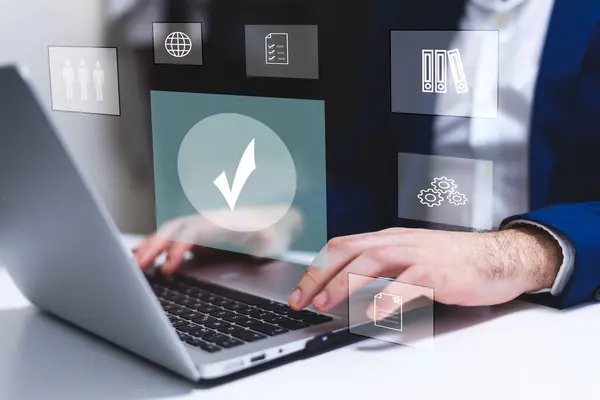 Kalite Güvencesi ve Sertifika Konsepti ikonları olan bir iş adamı dizüstü bilgisayar kullanıyor. Teknoloji ve Yenilik Konsepti.