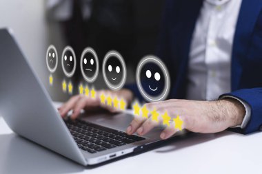 Müşteri memnuniyeti anketi kavramı dizüstü bilgisayarın arka planında resim ve simgelerle gösterilmiştir