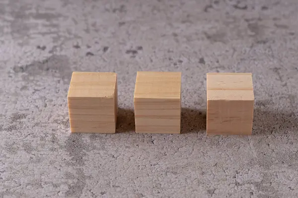 Dokulu bir yüzeyde üç tahta blok.