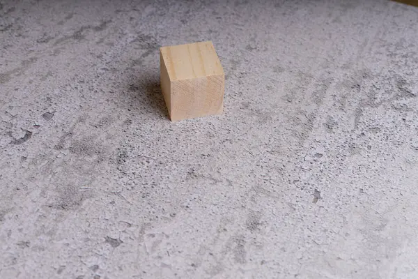 Dokulu bir yüzeyde tek bir tahta küp..