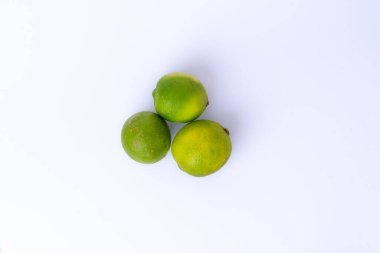 Beyaz arka planda tam kireç ve dilimler var. Taze tropikal narenciye, içecekler, yemek pişirme ve yemek dekorasyonu için mükemmel..