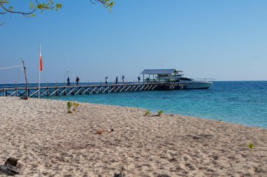 Makassar - Endonezya, 24 Eylül 2023: Karang Panambungan sahilinde güzel mavi deniz suyu ve beyaz kum manzaralı özel yat.