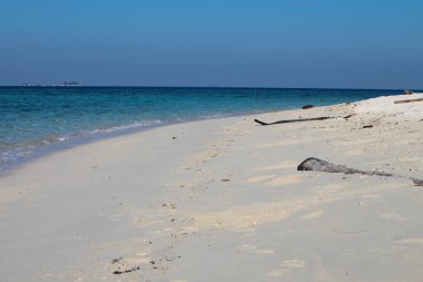Kumsaldaki kumlara ve mavi yaz gökyüzüne yakın. Panoramik plaj manzarası. Boş tropik plaj ve deniz manzarası.