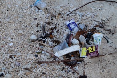 Makassar - Endonezya (09-2023): Plaja saçılmış plastik atık, sahil ziyaretçilerinden arta kalan yiyecek.