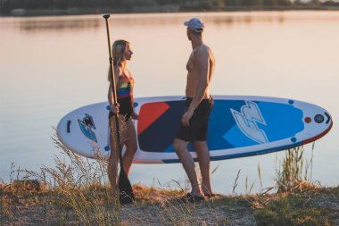 Erkek ve kadın sahilde durur.