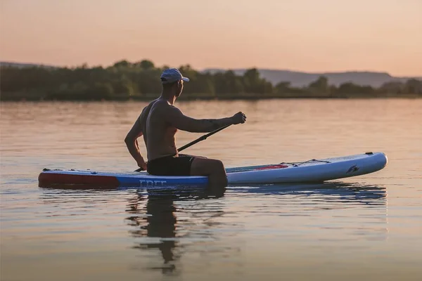 man kayaking in the river at sunset