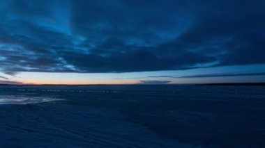 Finlandiya, Tampere 'de bir gölün üzerinde gece mavisine dönüşen bir kış akşamının zaman aşımı
