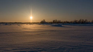 Finlandiya 'da kışın deniz kıyısında güneş batarken