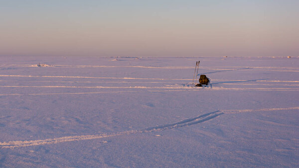 Winter hiking on the sea ice with sled full of equipment