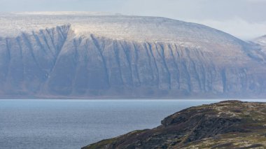 Kuzey Norveç 'te karlı fiyort kenarındaki dağlar